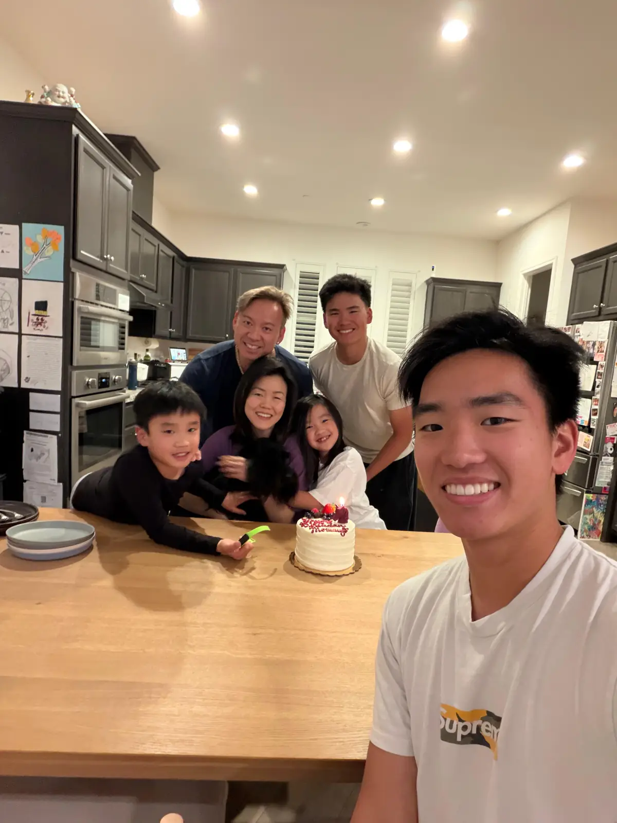 Gathered around a birthday cake at home